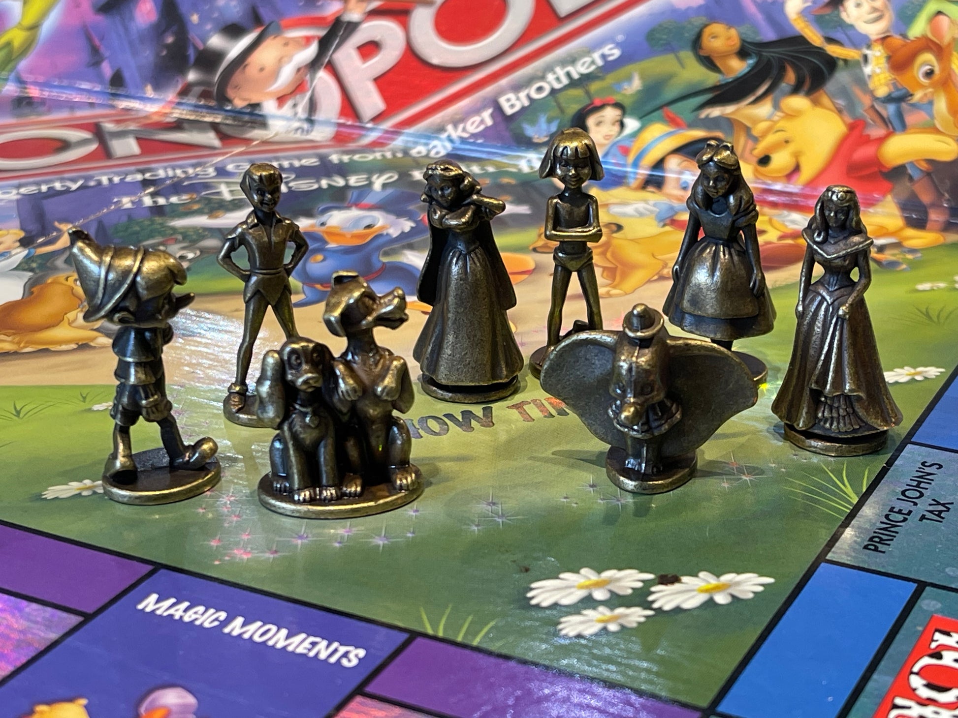 Conundrum House Game Library - Monopoly - the Disney Edition closeup of 8 player pieces - Mowgli, Pinocchio, Lady & the Tramp, Alice, Peter Pan, Dumbo, Snow White and Aurora..